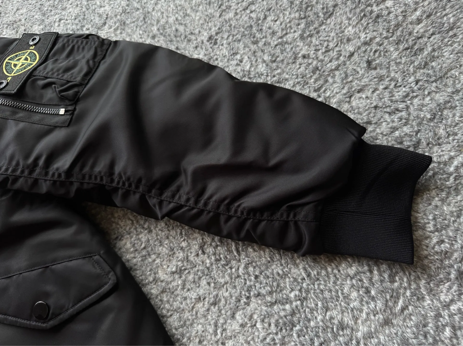P360 Stone lsland Stone Island Medal Aviator Cotton Jacket The outer fabric is made of MA-1 flight nylon, which is a material specially used in flight and aviation. Flying nylon is a fabric specially used in flight and aviation. It is rarely used in ordinary clothing. The density of flying nylon is very high, so it is windproof and waterproof. When rain falls on the surface of the clothes, it will not penetrate immediately, but will form a small water droplet and slide off. This performance is a requirement for the development of modern jet technology. Because it is assumed that the pilot got caught in the rain before getting on the plane, he entered the cabin covered in rainwater. When flying at high altitude and at high speed, in a cabin without an environmental control system, water droplets will freeze on the pilot's body 2. Knitted baseball collar MA-1 uses a knitted collar. The collar is made of wool and can be snug around the neck and very warm. 3. Metal zippers We have very strict requirements on zippers, including smoothness and size. There was no zipper on the market that met the requirements, so we asked a zipper factory to customize a strong and durable metal zipper.  4. Double-threaded knitted cuffs The cuffs are made of double-threaded knitted fabric, narrow at the front and wide at the back. The narrow part can be tightened around the wrist to prevent wind from entering. The wide part has enough space when wearing multiple pieces under winter Color: Black Dark Army Green Size: M L.